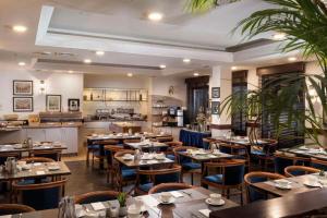 a restaurant with tables and chairs and a kitchen at Peine Salzgitter Hotel by Belvilla in Peine