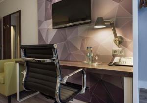 a chair sitting in front of a desk with a computer at Peine Salzgitter Hotel by Belvilla in Peine