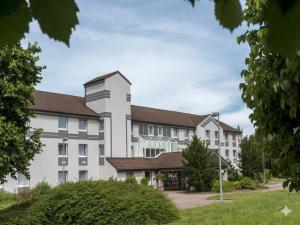 a large white building with a brown roof at Peine Salzgitter Hotel by Belvilla in Peine