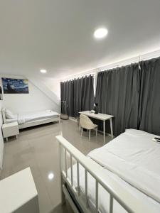 a bedroom with two beds and a desk and a table at Tiger Homestay in Bangkok