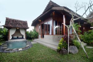 a house with a swimming pool in front of it at Pondok Kumpi ubud in Ubud