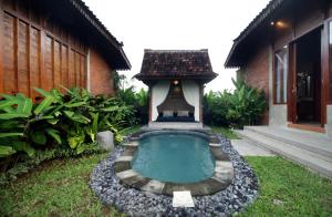 a small swimming pool in the yard of a house at Pondok Kumpi ubud in Ubud