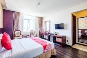 a hotel room with a bed and a television at GIC Land Hotel in Danang