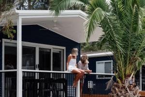 two women sitting on the balcony of a house at Tasman Holiday Parks - Kioloa Beach in Kioloa
