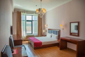 a hotel room with a bed and a mirror at Atlas Hotel in Ulaanbaatar