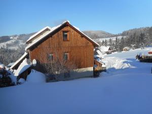 een houten hut in de sneeuw met sneeuw bij Chalupa Večerník in Rokytnice nad Jizerou