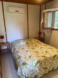 a bedroom with a bed and a window at La Palmeraie in Le Moule