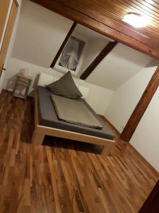 ein kleines Bett in einem Zimmer mit Holzböden in der Unterkunft Vatan Apartment in Fürth