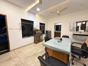 a living room with a table and chairs in it at Triple A Gardens in Kollam