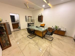 a kitchen with a table and chairs in a room at Triple A Gardens in Kollam +13 photos