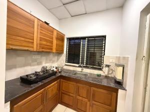 a kitchen with wooden cabinets and a sink at Triple A Gardens in Kollam