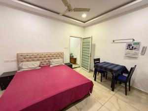 a bedroom with a large bed and a table at Triple A Gardens in Kollam