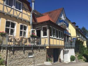 a yellow house with a balcony on the side of it at Hotel Sonneck in Schwäbisch Hall