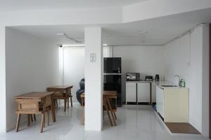 a kitchen and dining room with a table and chairs at New Hostel Braga in Bandung