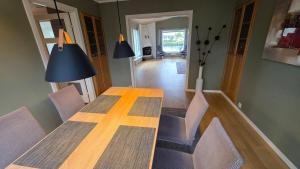 a dining room table with chairs and a blue lamp at Prestelandet Guesthouse in Fredrikstad