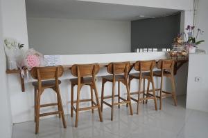 a kitchen with a bar with four wooden stools at New Hostel Braga in Bandung +19 photos