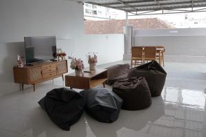 a living room with a couch and a tv and a table at New Hostel Braga in Bandung
