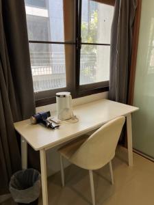 a table and a chair in front of a window at Tiger Homestay in Bangkok