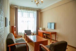 a living room with a table and chairs and a desk at Atlas Hotel in Ulaanbaatar