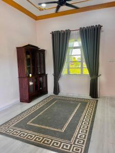 a living room with a rug and a window at Ramly Homestay in Kuala Terengganu +1 photo