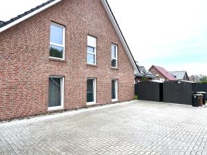ein Backsteingebäude mit einem Parkplatz davor in der Unterkunft "Nemo" Papenburg ebenerdig rollstuhlgerecht 83 qm Neubau EBK 2 Schlafzimmer 4 Personen Free Wifi in Papenburg