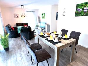 ein Wohnzimmer mit einem Holztisch und Stühlen in der Unterkunft "Nemo" Papenburg ebenerdig rollstuhlgerecht 83 qm Neubau EBK 2 Schlafzimmer 4 Personen Free Wifi in Papenburg