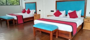 a bedroom with two beds with red and blue pillows at Park Paradise in Galle