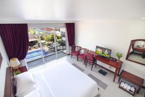 a hotel room with a bed and a desk and a window at Sala Siem Reap Hotel in Siem Reap