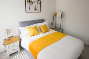 a bedroom with a large bed with yellow pillows at Cosy 5 Bedroom House With Parking in Chatham