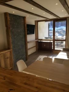 ヴァル・ディゼールにあるAppartement vue 180° sur massifのテーブルと椅子、窓が備わる客室です。