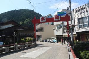 a red sign on a street in a town at 郡上八幡 貸宿 GujoHachiman Kashiyado ICHI in Gujo