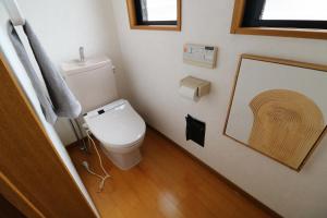 a bathroom with a toilet and a picture on the wall at 郡上八幡 貸宿 GujoHachiman Kashiyado ICHI in Gujo +21 photos