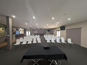 a conference room with a black table and white chairs at Weipa Motel Resort in Weipa