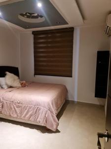 a bedroom with a bed and a window with blinds at Depa YAZI in Villahermosa