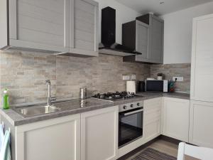 a kitchen with white cabinets and a sink at Da Fede al mare in Moneglia