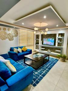 a living room with a blue couch and a coffee table at Depa YAZI in Villahermosa