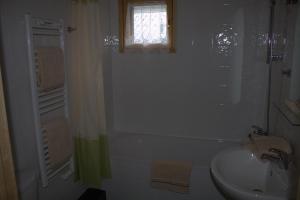 a white bathroom with a sink and a window at Les Chalets Fleurs de France - KOTA in Saint-Dalmas +22 photos
