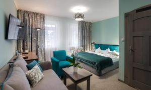 a hotel room with a bed and a couch at Artus Resort in Karpacz +27 photos