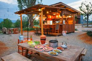 a picnic table with plates of food on top of it at Baannok at Motakhian in Pak Chong