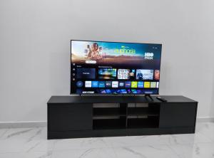 a flat screen tv sitting on top of a black stand at SELAMA Merdeka Homestay 2-6pax in Selama +4 photos