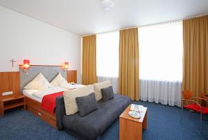 a hotel room with a bed and a couch at Martinshof in Rottenburg