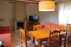 a living room with a table and a couch and a television at Villas Los Olivares - Deniasol in Els Poblets