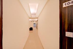 a long hallway with a white wall and a ceiling at Townhouse Gandhi Medical College Bhopal Formerly Hotel Shagun in Bhopal