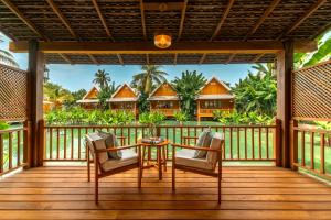 a deck with chairs and a table with a view of a resort at The Jam Boutique Hotel in Luang Prabang