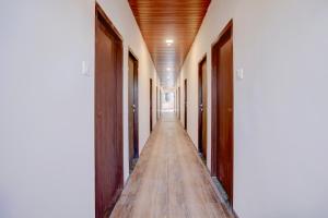 an empty corridor of a building with wooden floors and doors at Collection O IIM Mumbai Formerly Green View in Mumbai