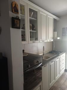 a kitchen with white cabinets and a sink at SsaZza in Râmnicu Vâlcea