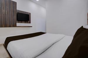 a bedroom with a bed and a tv on a wall at Collection O IIM Mumbai Formerly Green View in Mumbai +28 photos