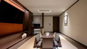 a dining room with a table and chairs and a tv at Anook Resort & Spa Busan Haeundae in Busan