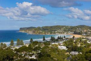 a view of a beach with houses and the ocean at Avoca Infinity - Expansive Haven with Ocean Panorama in Terrigal