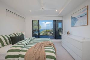 a bedroom with a bed and a large window at Avoca Infinity - Expansive Haven with Ocean Panorama in Terrigal
